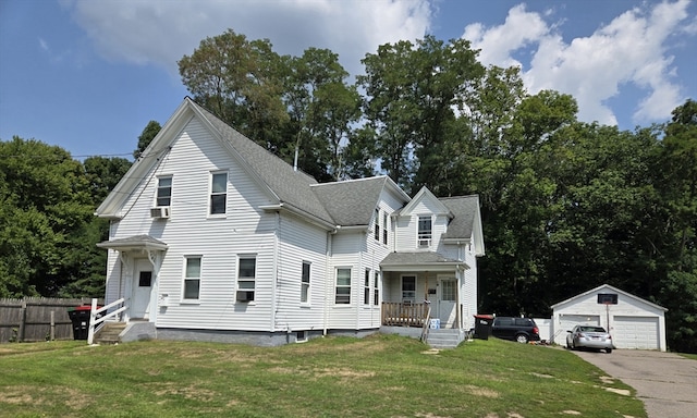 view of front property with cooling unit, a front yard, a porch, an outbuilding, and a garage