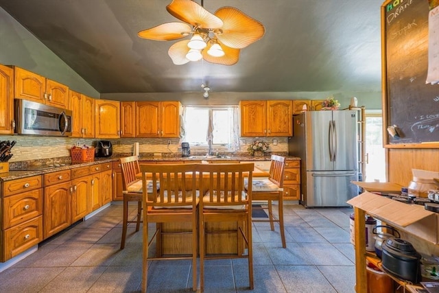 8 High St, Granby, MA 01033 - kitchen with stainless steel appliances, backsplash, a ceiling fan, brown cabinetry, and lofted ceiling