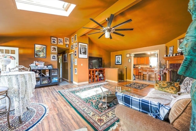8 High St, Granby, MA 01033 - living room with ceiling fan, a skylight, vaulted ceiling, wood finished floors, and a fireplace