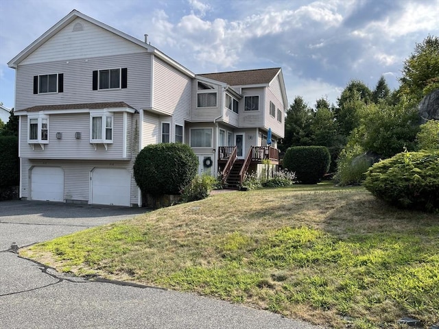 view of front of house featuring driveway, stairway, an attached garage, and a front yard