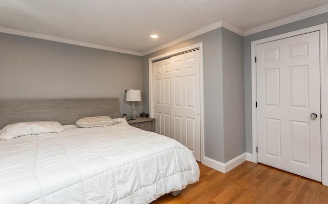 bedroom featuring a closet, crown molding, and light hardwood / wood-style flooring