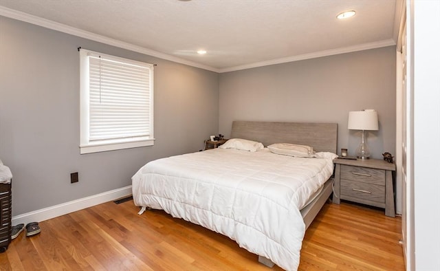 bedroom featuring ornamental molding and light hardwood / wood-style floors