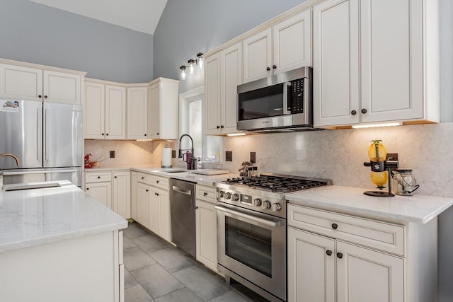 kitchen with tasteful backsplash, appliances with stainless steel finishes, sink, and light stone counters