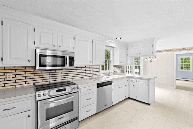 91 Observatory Waye, Marshfield, MA 02050 - kitchen with appliances with stainless steel finishes, baseboard heating, light countertops, a peninsula, and a textured ceiling
