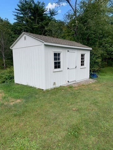 view of outbuilding with a yard