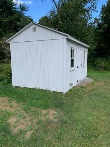 view of outbuilding featuring a lawn