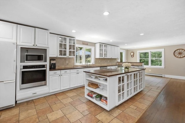 12 Whitcomb Ln, Hingham, MA 02043 - kitchen featuring stainless steel oven, freestanding refrigerator, dark countertops, open shelves, and decorative backsplash