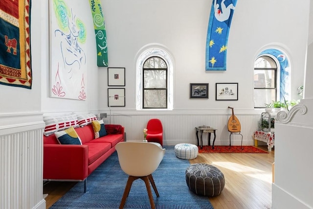 sitting room featuring wood finished floors and a wainscoted wall