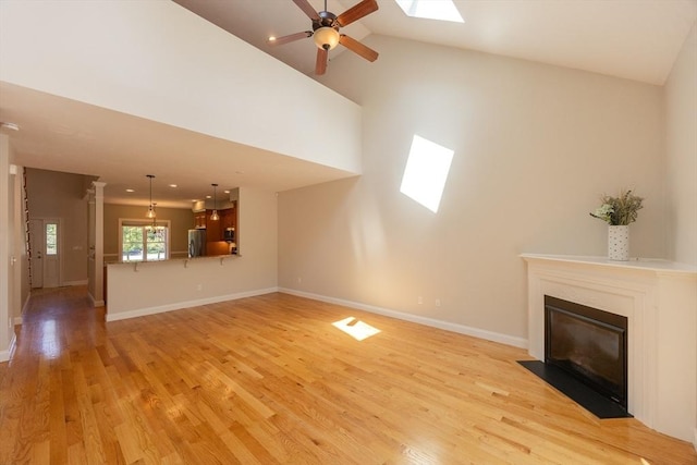 10 Chase Lndg Unit B, Easton, MA 02375 - unfurnished living room featuring a fireplace with flush hearth, a skylight, light wood finished floors, ceiling fan, and baseboards