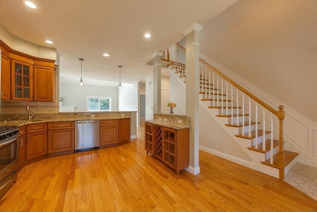 10 Chase Lndg Unit B, Easton, MA 02375 - kitchen with stainless steel appliances, brown cabinetry, a sink, glass insert cabinets, and light stone counters