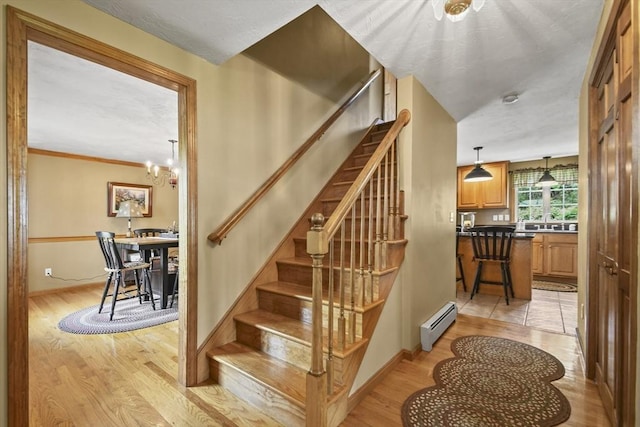 18 Jackson Ave, Rutland, MA 01543 - stairs with baseboard heating, wood finished floors, a chandelier, and baseboards