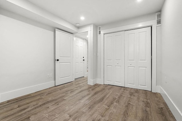 50 Cottage St Unit 1, Chelsea, MA 02150 - unfurnished bedroom with wood finished floors, baseboards, recessed lighting, and a closet