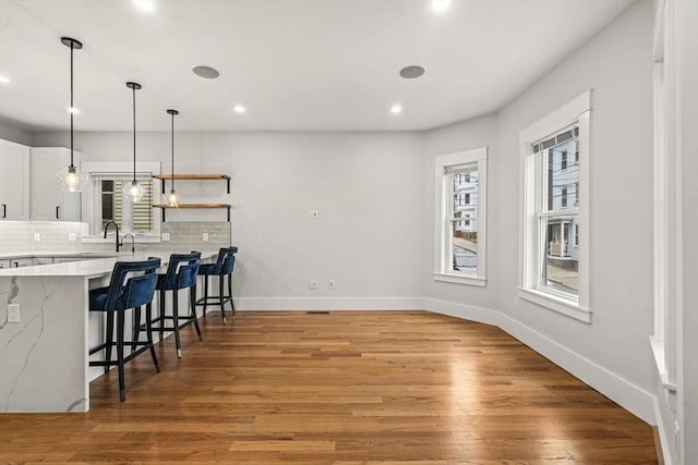 50 Cottage St Unit 1, Chelsea, MA 02150 - dining space featuring baseboards, light wood-type flooring, recessed lighting, and bar with sink
