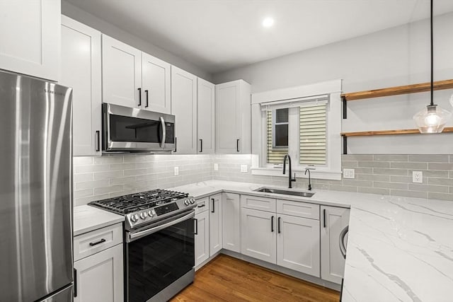 50 Cottage St Unit 1, Chelsea, MA 02150 - kitchen with stainless steel appliances, a sink, light stone countertops, light wood-style flooring, and white cabinets