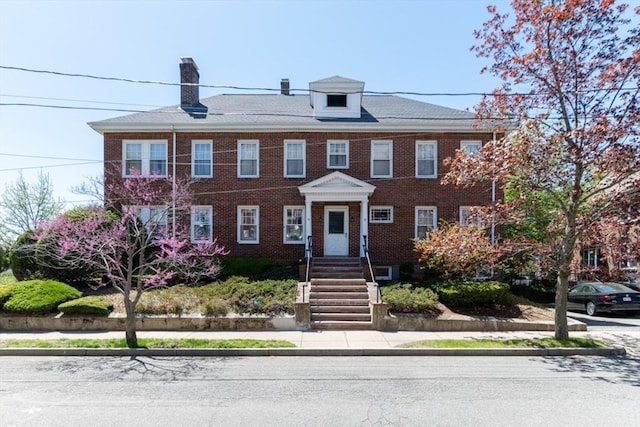multi unit property featuring brick siding and a chimney