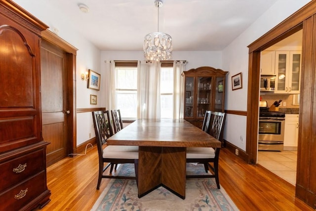 dining area featuring baseboards, a notable chandelier, and wood finished floors
