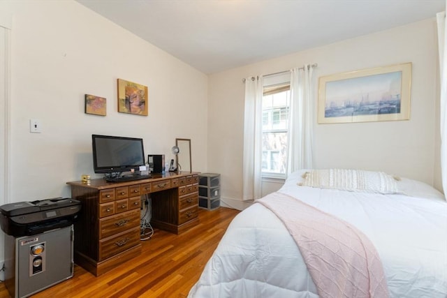 bedroom with baseboards and wood finished floors
