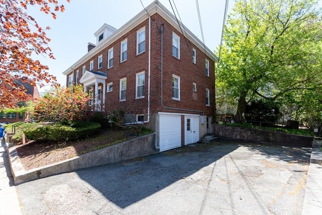 view of side of property with brick siding and a garage