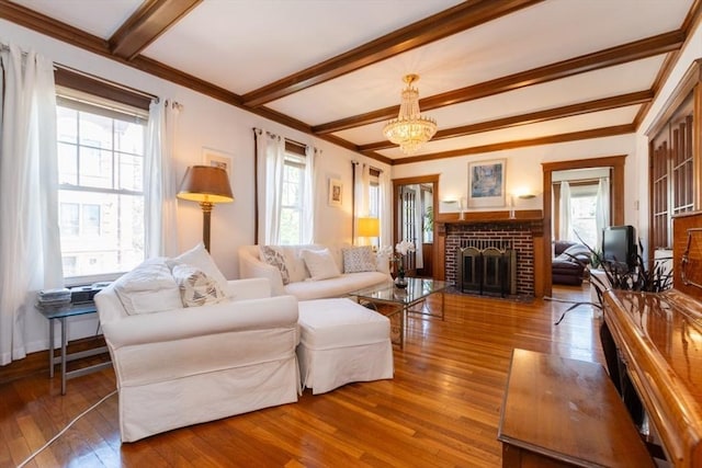 living area with wood-type flooring, crown molding, plenty of natural light, and beam ceiling