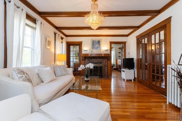 living room featuring french doors, plenty of natural light, wood finished floors, and a chandelier
