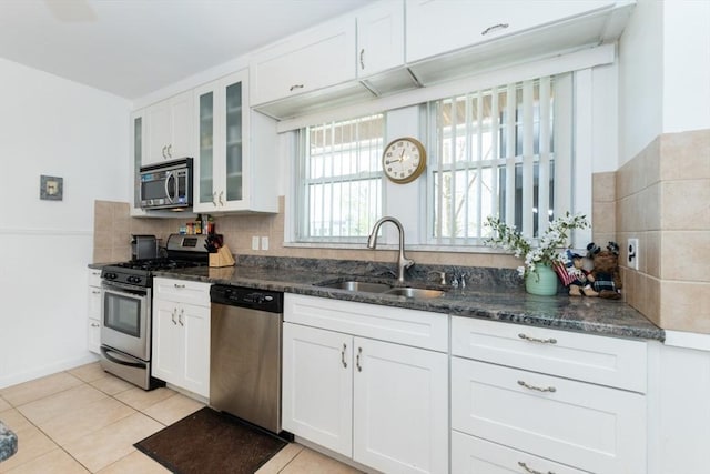 kitchen with white cabinetry, appliances with stainless steel finishes, a sink, and tasteful backsplash