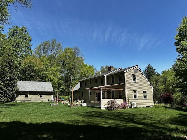 back of house with a chimney and a lawn