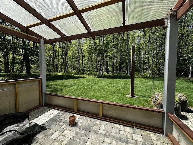 unfurnished sunroom with a forest view and vaulted ceiling