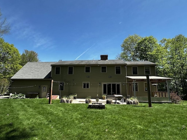 rear view of property with a patio area, a chimney, and a yard