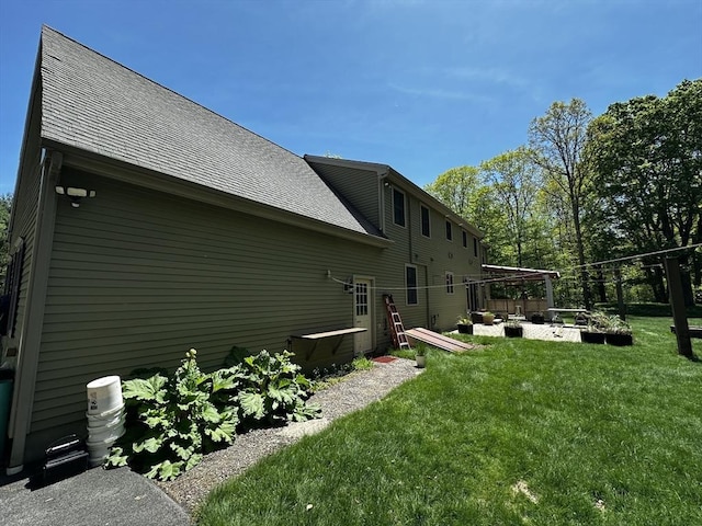 view of home's exterior featuring a lawn and roof with shingles