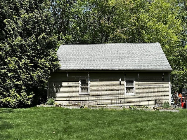 view of home's exterior featuring a yard and roof with shingles