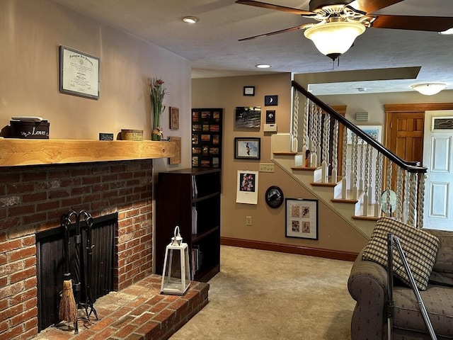 living room with a fireplace, carpet, stairs, ceiling fan, and baseboards