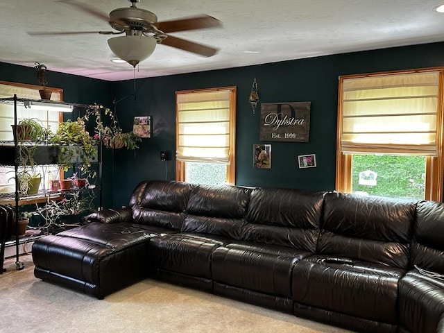 carpeted living area with healthy amount of natural light and a ceiling fan