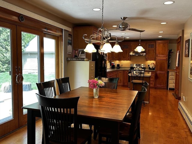 dining room with a baseboard radiator, recessed lighting, a chandelier, a ceiling fan, and wood finished floors