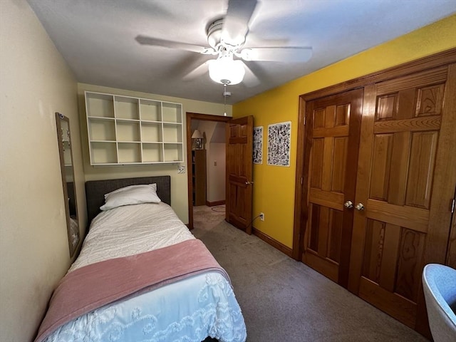carpeted bedroom with a ceiling fan, a closet, and baseboards