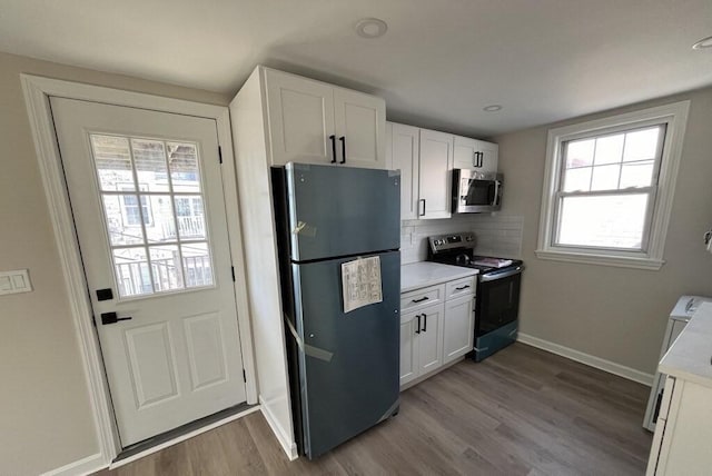 561-A E 6th St, Boston, MA 02127 - kitchen featuring stainless steel appliances, dark wood-style flooring, light countertops, backsplash, and white cabinets