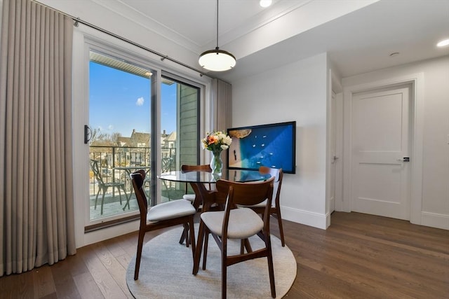 dining area with ornamental molding and dark hardwood / wood-style floors