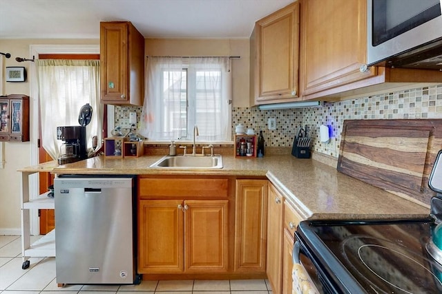 kitchen with stainless steel appliances, light countertops, a sink, and backsplash