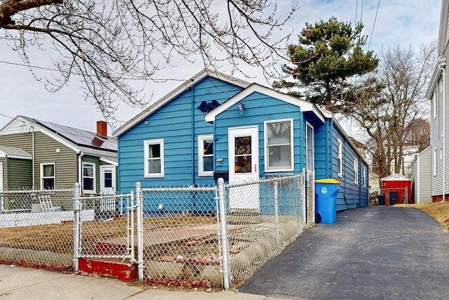 bungalow-style home featuring a fenced front yard and a gate