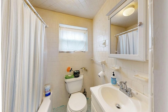 full bathroom with toilet, shower / bath combination with curtain, a sink, and tile walls