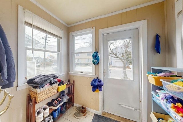 entryway with tile patterned flooring, crown molding, and wooden walls