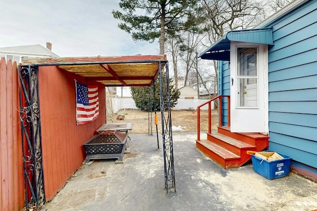 view of patio featuring an outdoor fire pit and fence