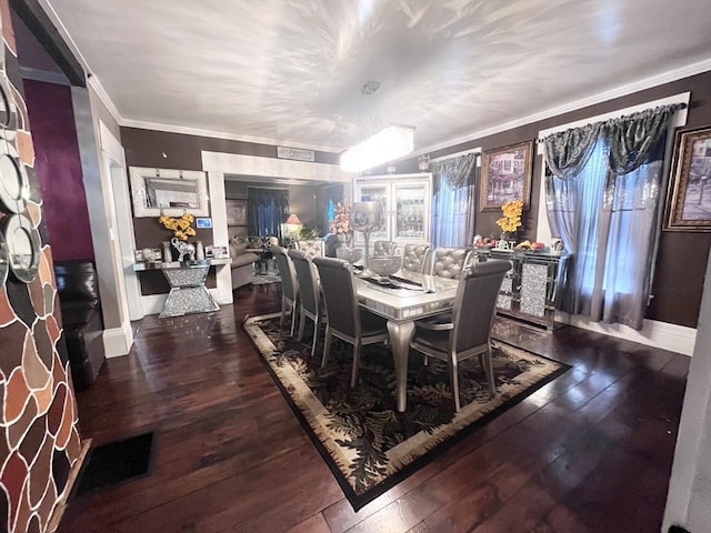 dining space featuring crown molding and dark wood-type flooring