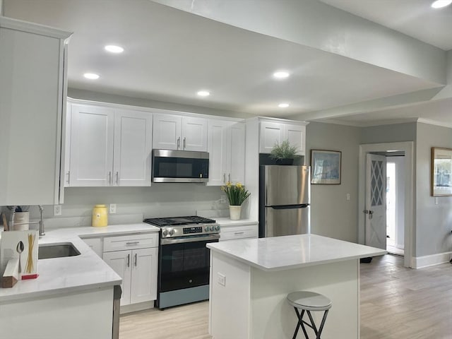 43 Aubin St Unit 1, Amesbury, MA 01913 - kitchen featuring stainless steel appliances, light wood-style floors, white cabinetry, a center island, and recessed lighting