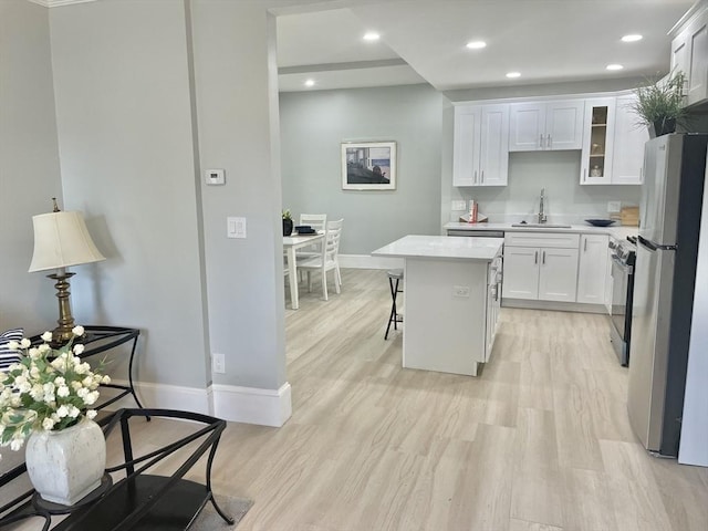 43 Aubin St Unit 1, Amesbury, MA 01913 - kitchen with freestanding refrigerator, baseboards, range with gas cooktop, light countertops, and a sink