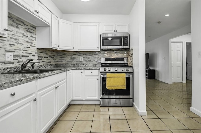 312 Water St Unit 1, Lawrence, MA 01841 - kitchen featuring appliances with stainless steel finishes, a sink, light tile patterned floors, and decorative backsplash