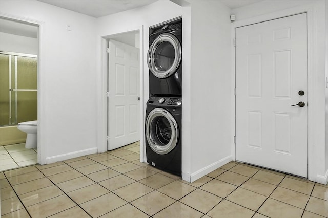 312 Water St Unit 1, Lawrence, MA 01841 - laundry room featuring estacked washer and dryer, light tile patterned floors, and baseboards