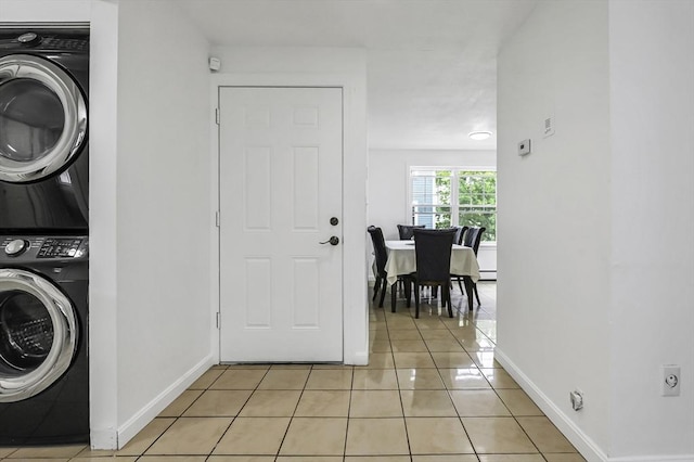 312 Water St Unit 1, Lawrence, MA 01841 - laundry area featuring stacked washer and clothes dryer, light tile patterned floors, baseboards, and baseboard heating