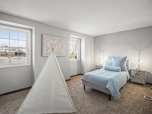 bedroom with a textured ceiling, baseboards, and carpet flooring