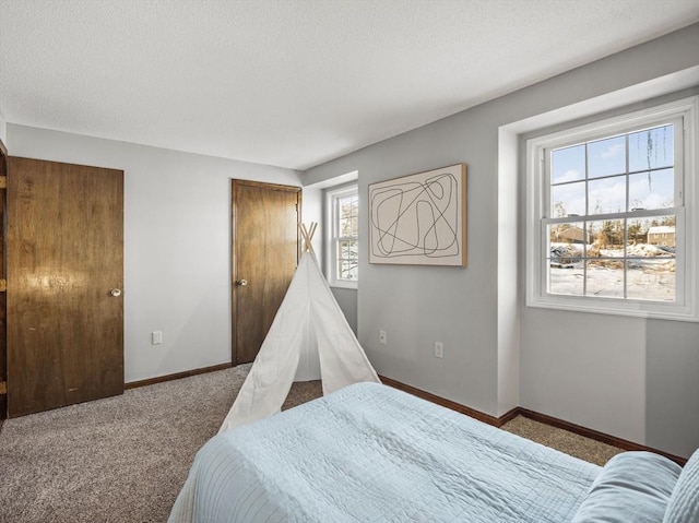 carpeted bedroom with a textured ceiling and baseboards