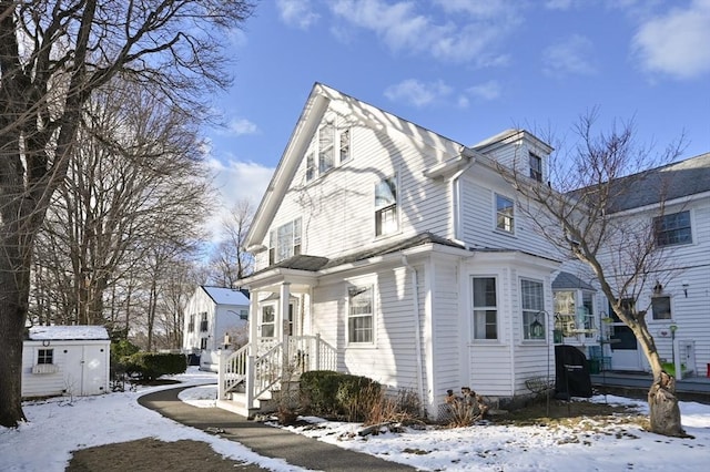 snow covered property with a storage unit